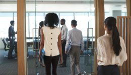 Rear View Of Businesspeople Entering Boardroom For Meeting