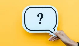 Cropped view of woman holding speech bubble with question mark on orange (R) (S) Cropped view of woman holding speech bubble with question mark on orange (R) (S)