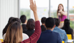 young businesswoman raising hand to question from Speaker in Seminar. Group Meeting . Conference Concept . Rear back view