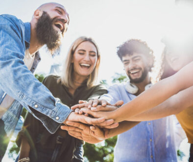 Multiracial happy young people stacking hands on top of each other - Diverse friends unity togetherness in volunteer community - Concept about college, relationship, youth and human resources