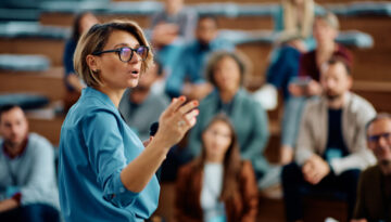 Female speaker giving a presentation during business seminar at convention center.