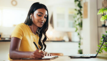 Laptop, woman and writing notes for elearning, webinar course or remote education in home. Computer, college student and notebook in virtual meeting, study and earphones for lesson in online class