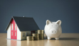 Saving money for house concept with white piggy bank